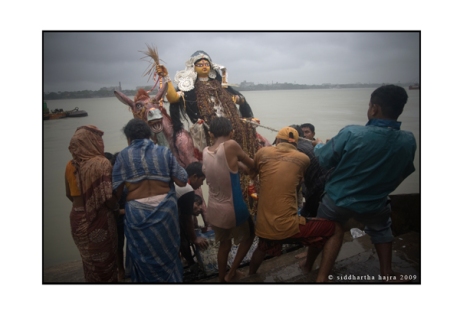 godess sitala being immersed into the river hoogly, calcutta, may 25 2009